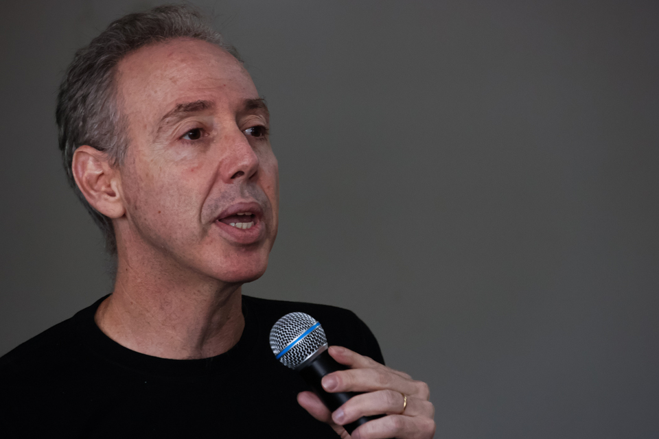 Homem branco falando ao microfone